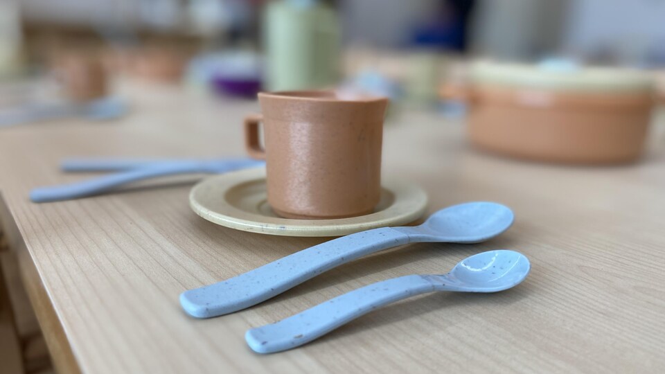 Des ustensiles et une tasse sur une table en bois.