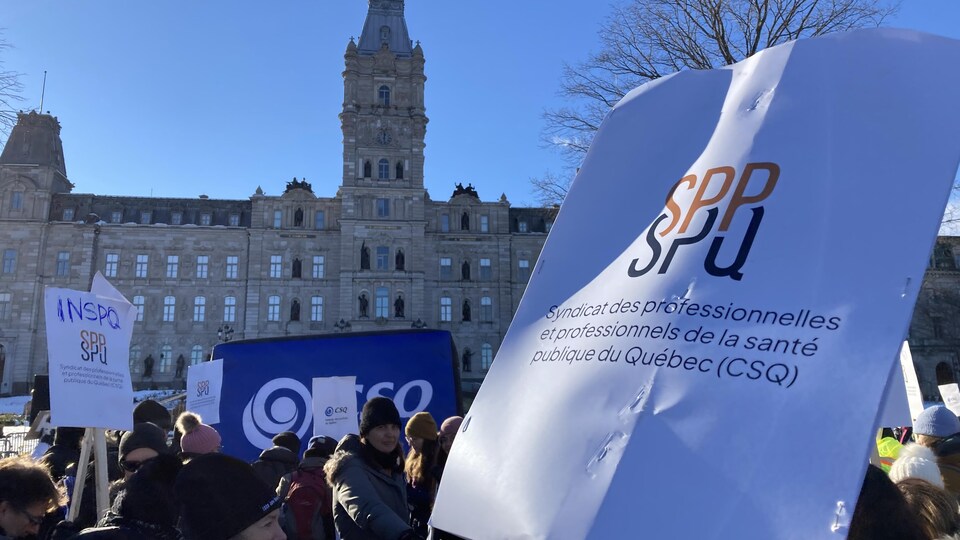 Des employés de l'INSPQ manifestent devant l'Assemblée nationale une journée de novembre ensoleillée.