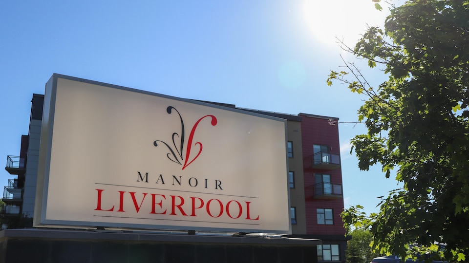 Une affiche du Manoir Liverpool à l'extérieur, au soleil.