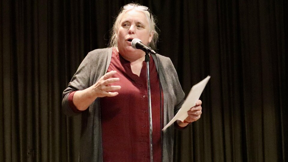 Manon Massé, debout, parle au micro.