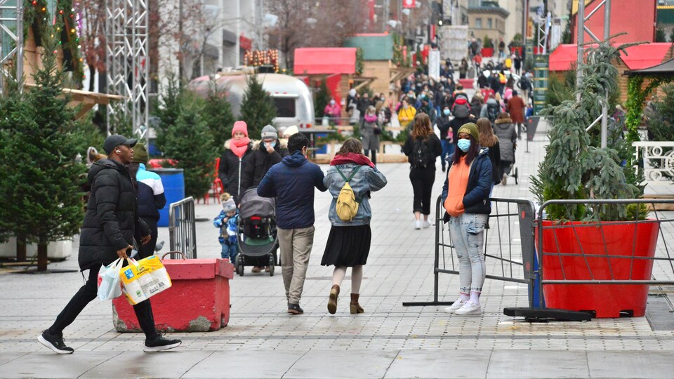 Des gens marchent dans un marché de Noël.