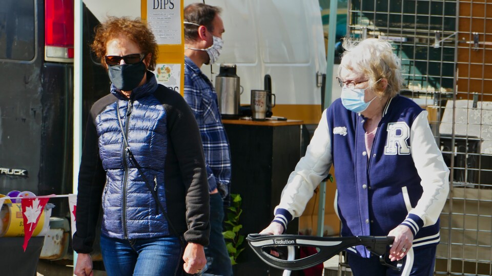 Des gens portant des masques au marché de fermiers de Regina en automne.