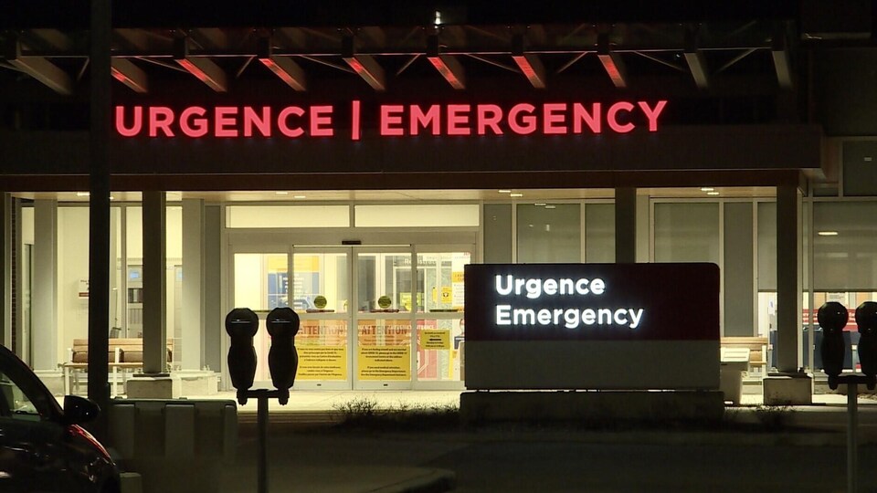 Façade de l'hôpital la nuit et de son urgence.