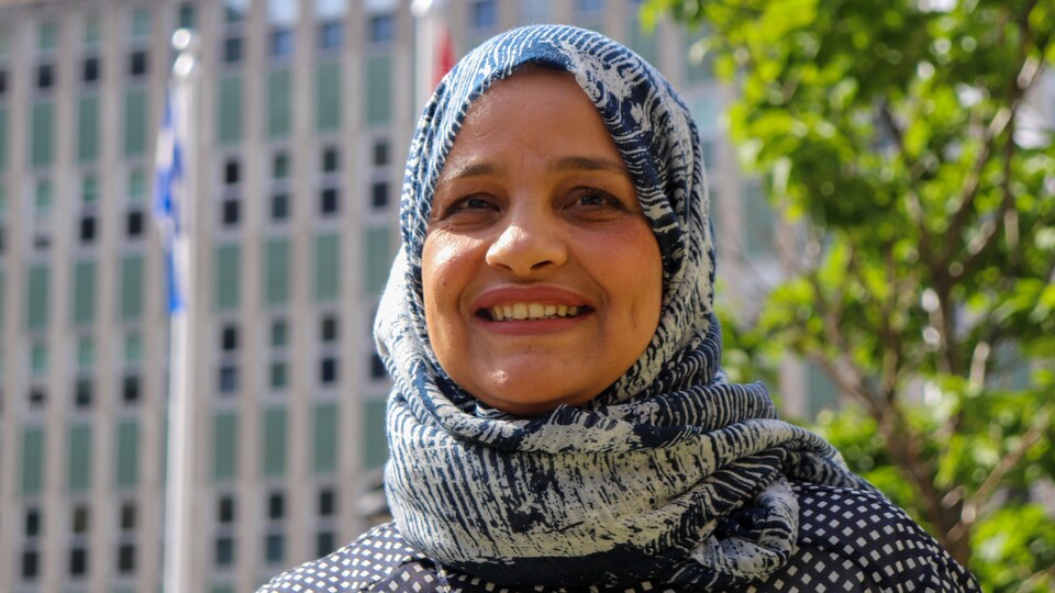 Portrait de Najwa Essid. Elle sourit. À l'arrière-plan, on distingue un arbre et un établissement de santé.