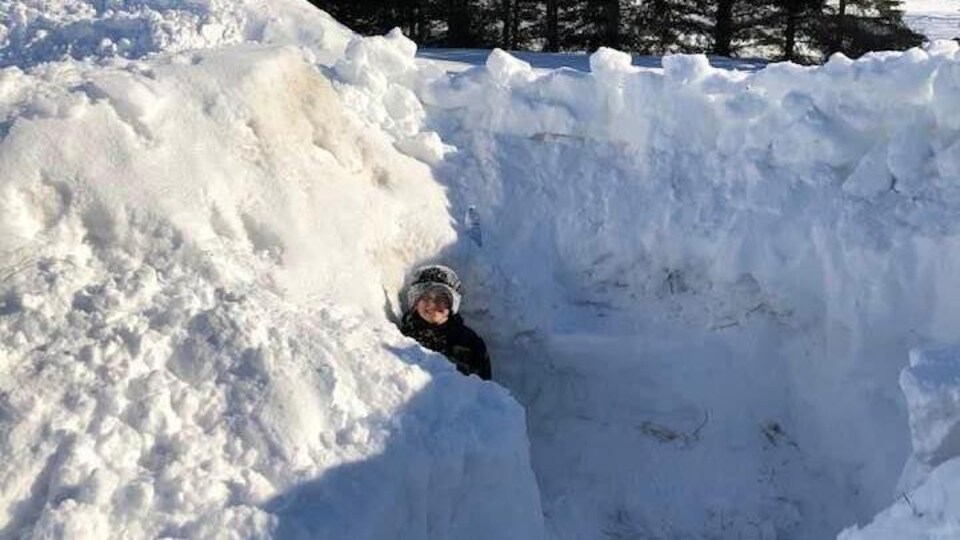 Un des enfants de Valérie Charbonneau dans son fort de neige.