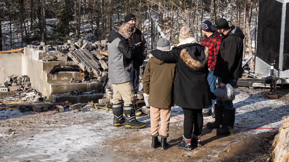 Un groupe de citoyens se réunit sur les lieux où un grave incendie a fait rage la veille.