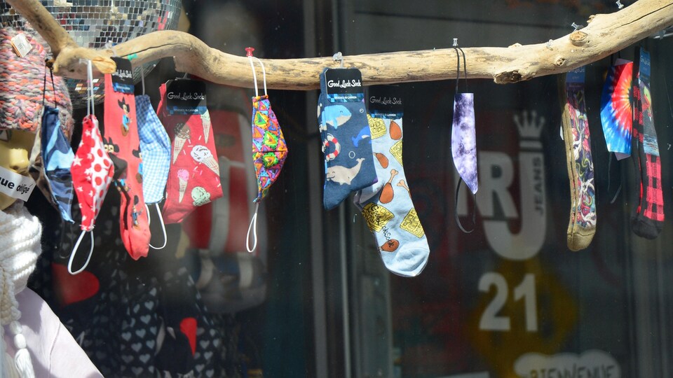 Des masques et des chaussettes pendent sur une bâton.