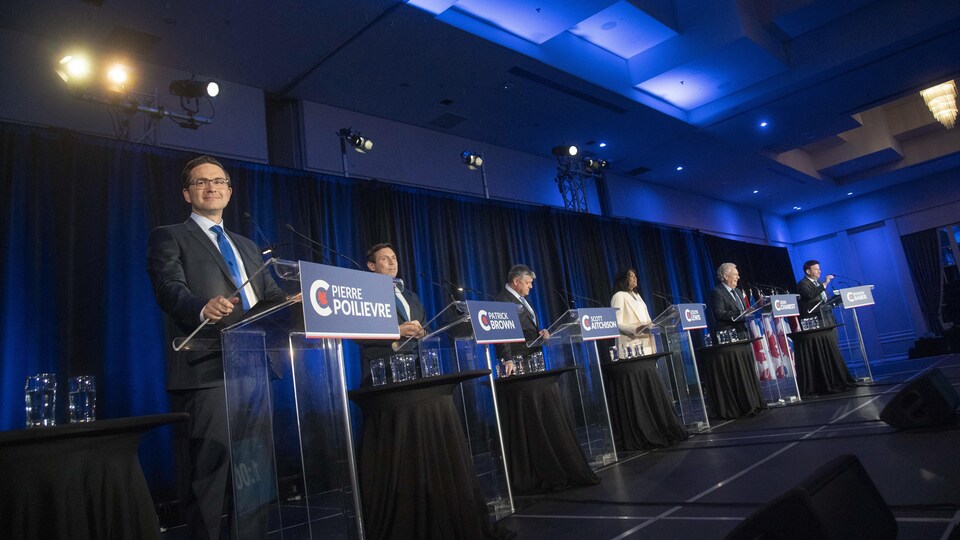 Les six candidats sur une scène.