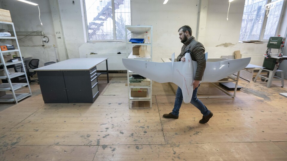 Oleksander Pinchuk qui marche avec un avion UAV, (unmanned aerial vehicule) dans le centre de production de la compagnie Athlon-Avia à Lviv.