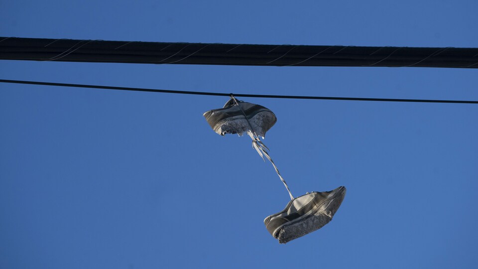 Des souliers accrochés à un fil électrique.