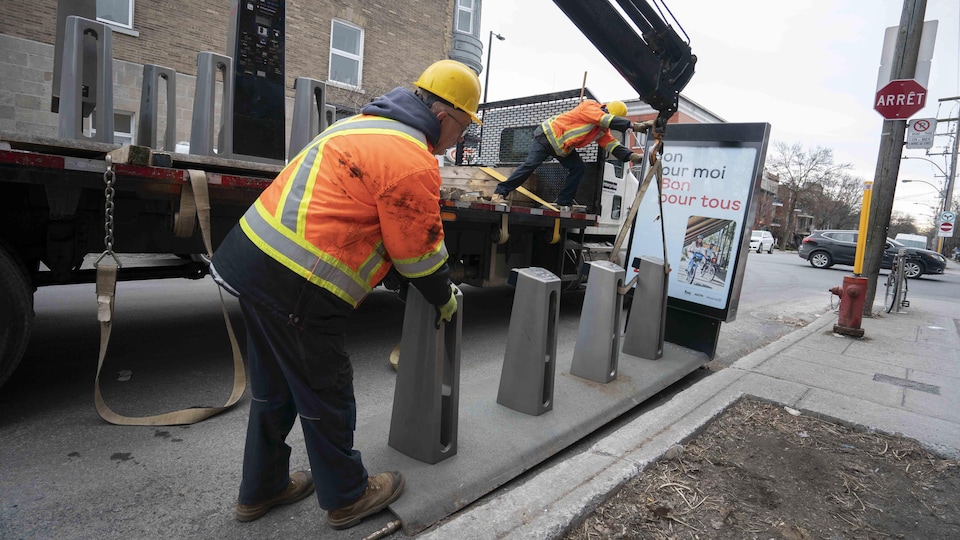 Workers install a BIXI station in Montreal.