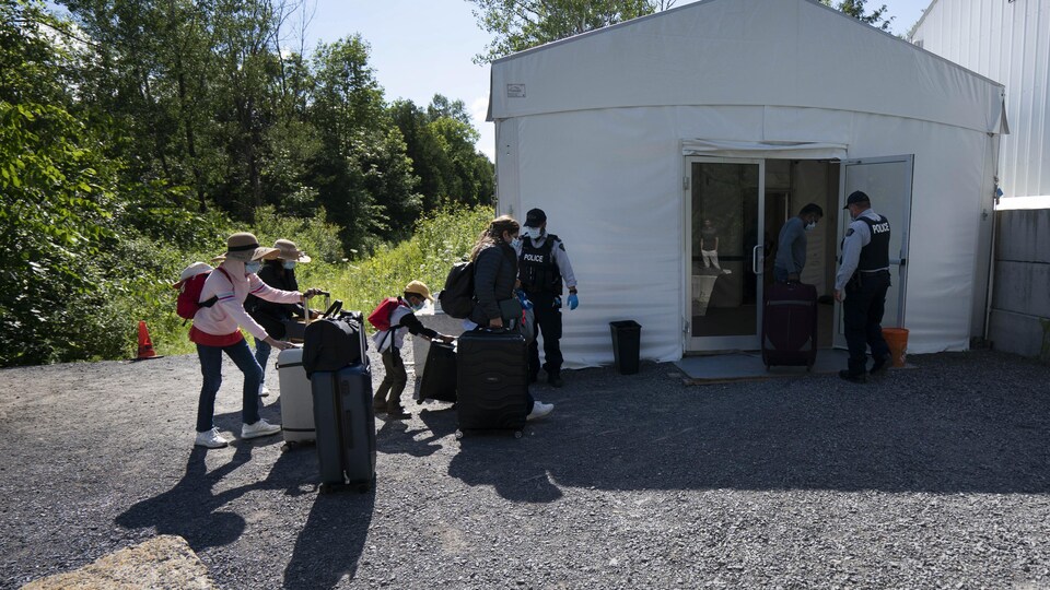 Des migrants avec leurs valises.