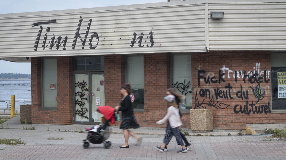 Un graffiti traverse comme une balafre la devanture du Tim Hortons.