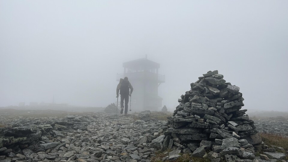 Un épais brouillard enveloppe le sommet de la montagne