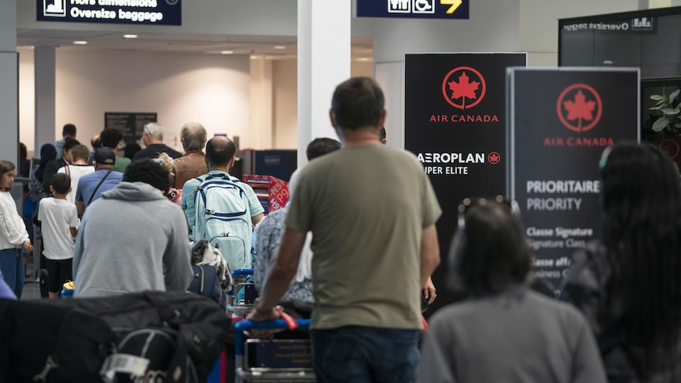 Une file de passagers à l'aéroport Pierre-Elliott-Trudeau, près des comptoirs d'Air Canada.
