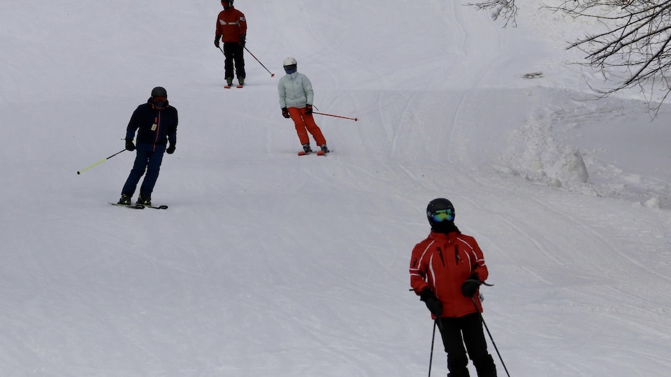 Des skieurs en train de descendre une pente.