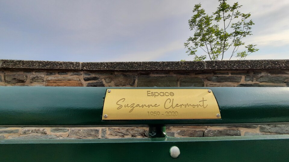 Une plaque dorée portant l'inscription «Espace Suzanne-Clermont» est installée sur un banc