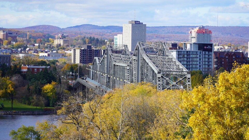 Le pont, quelques édifices du centre-ville et des arbres au couleurs d'automne en arrière plan.