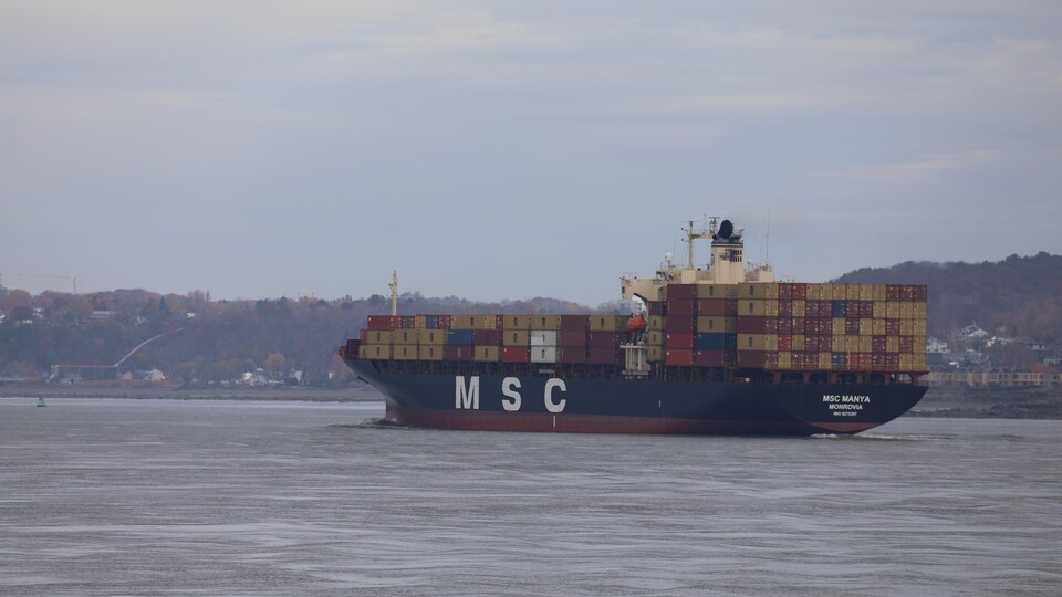 Un bateau rempli de conteneurs sur le fleuve.