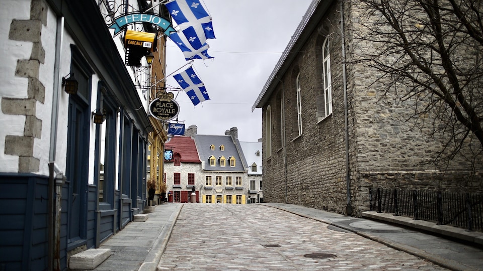 Le quartier Petit Champlain avec le drapeau québécois sur les façades est vide de monde.
