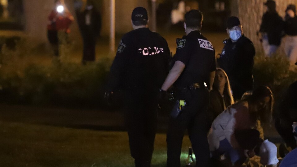 Trois policiers dans un parc la nuit.