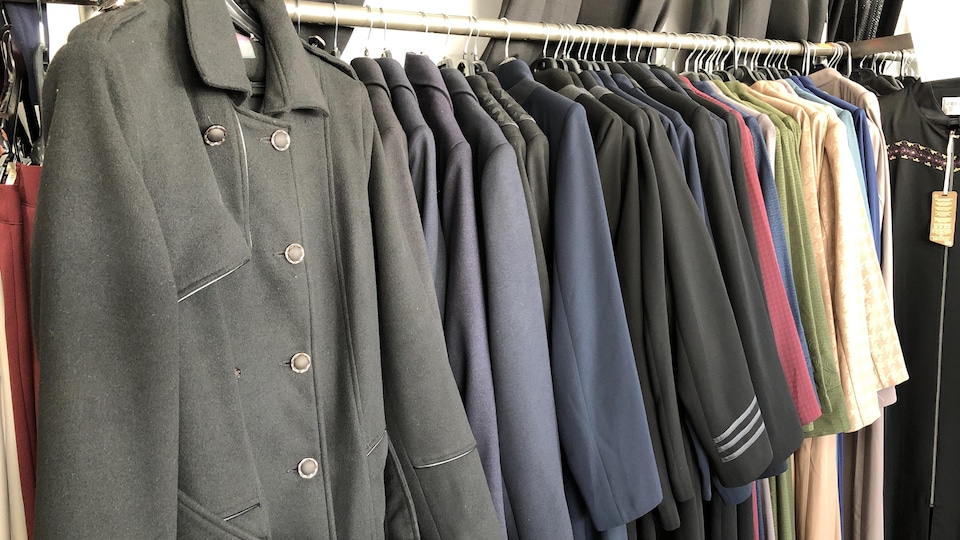 Des manteaux dans une boutique de vêtements.