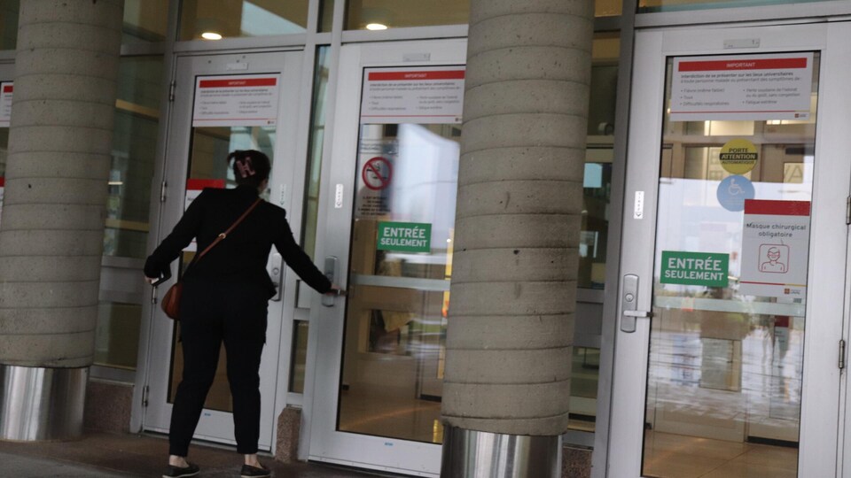 Un étudiant à l'entrée de l'Université Laval.