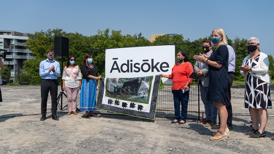 Des gens présentent une affiche et applaudissent.