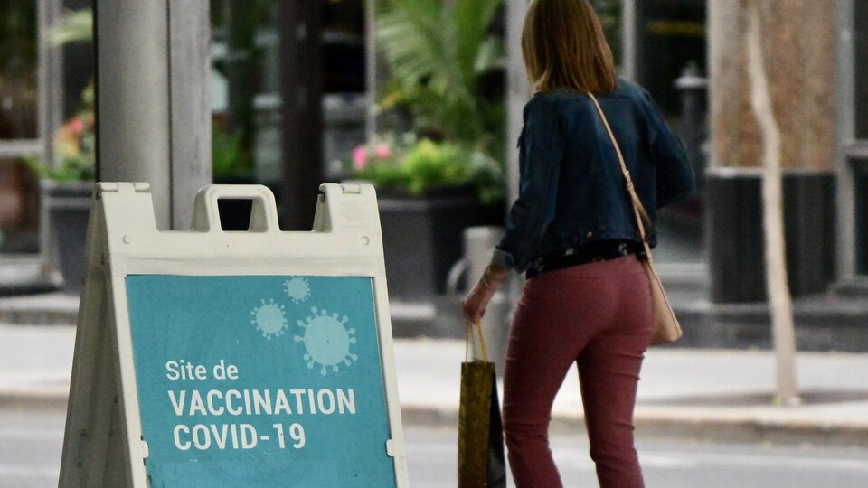 Une femme passe devant une clinique de vaccination.