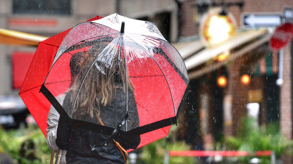 Des gens se promènent avec des parapluies.