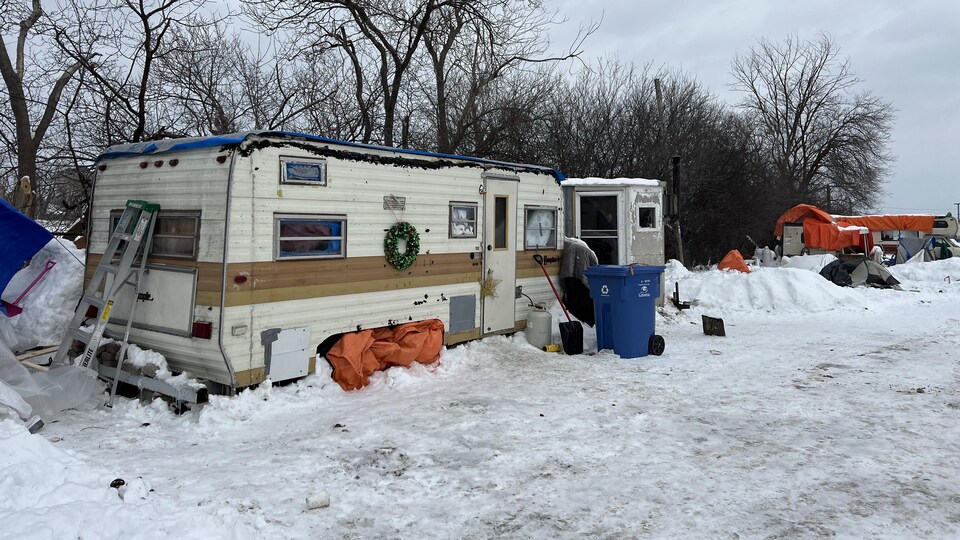 Une maison mobile et des poubelles installées près du Gîte Ami, à Gatineau.