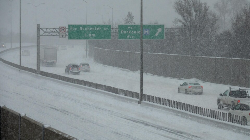 Des voitures sur une autoroute en pleine tempête de neige.