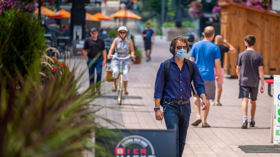 La rue Sparks à Ottawa, en été, avec des passants masqués.