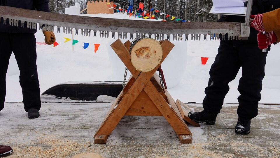 Une compétition de sciage de bûche au Carnaval Saint-Isidore, à Saint-Isidore, dans le nord de l'Alberta, en hiver. 