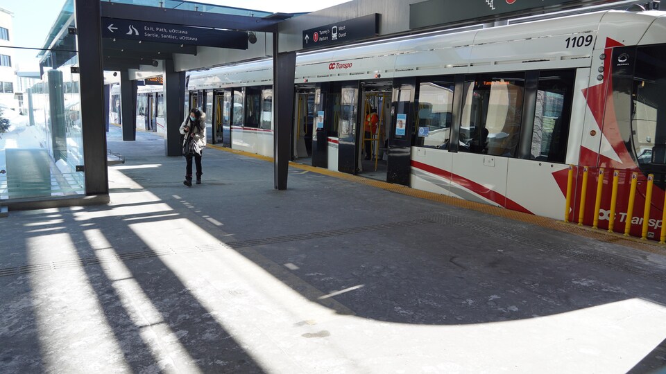 Un train léger est à quai avec les portes ouvertes.