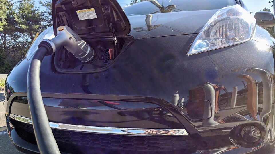 Une voiture électrique en train d'être chargée.
