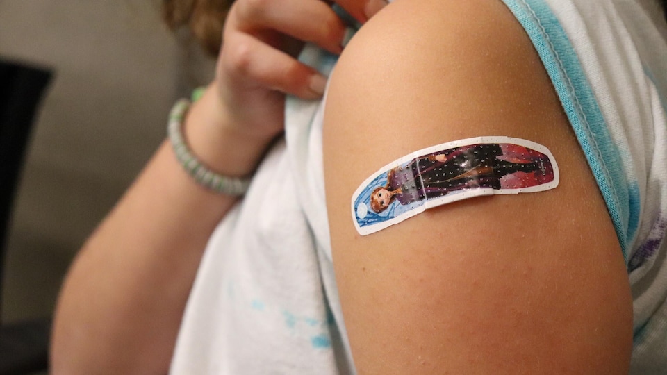 Un pansement à l'effigie d'un personnage du film Frozen sur le bras d'une enfant à l'endroit où elle a été vaccinée.