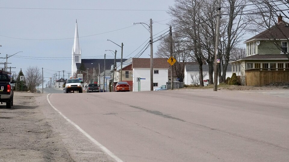 Une rue du village et le clocher de l'église dans le lointain.