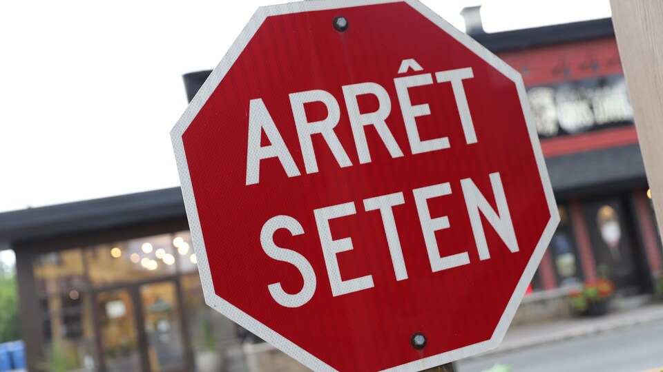 Une signalisation mentionnant Arrêt et la traduction en langue wendat, Seten.