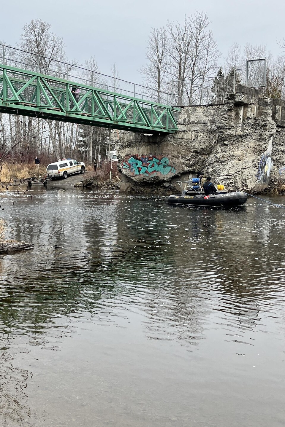 Un pneumatique sur la rivière Rimouski, avec un véhicule de la SQ aux abords.