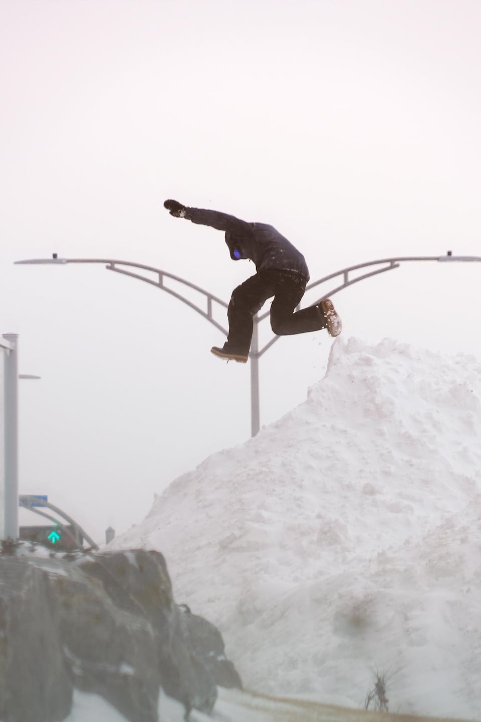 Un jeune s'amuse sur une bute de neige à Rimouski, pendant la tempête du 18 février 2025.