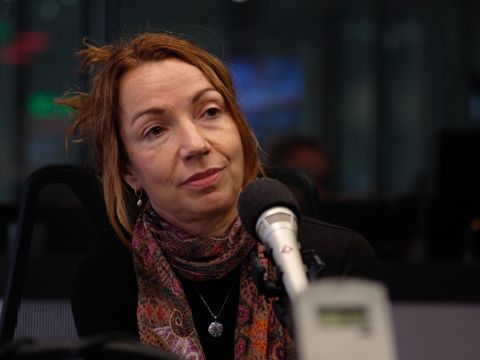 Martine Ouellet devant un micro dans un studio.