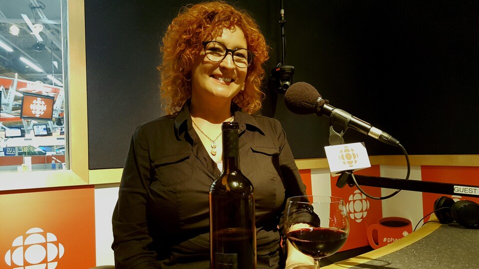 Louise-Marie Lessard, consultante en vins et chroniqueuse, pose derrière le microphone dans un studio avant sa chronique