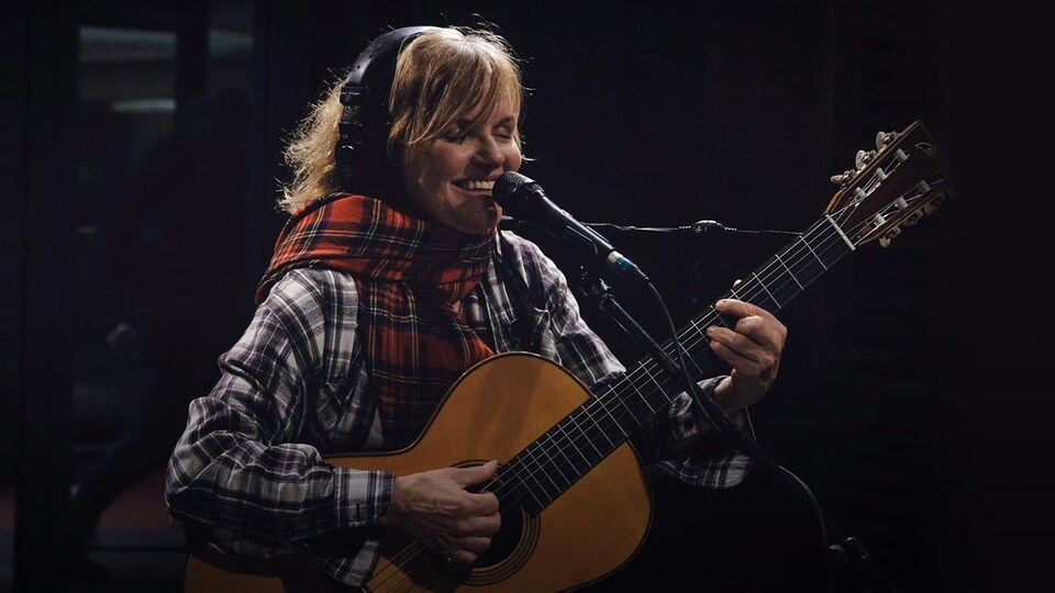 Diane Tell est souriante en chantant et en jouant de la guitare dans le studio de Tellement Courteau.