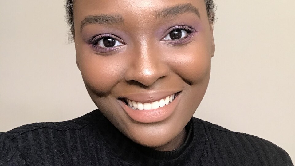 Jeune femme souriante sur fond neutre