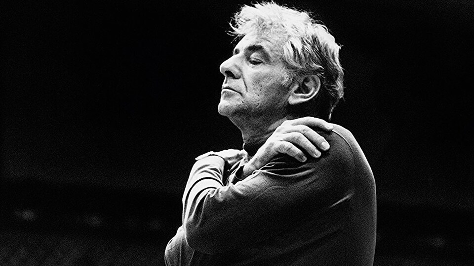 Maestro Leonard Bernstein, les yeux clos, écoute la musique
