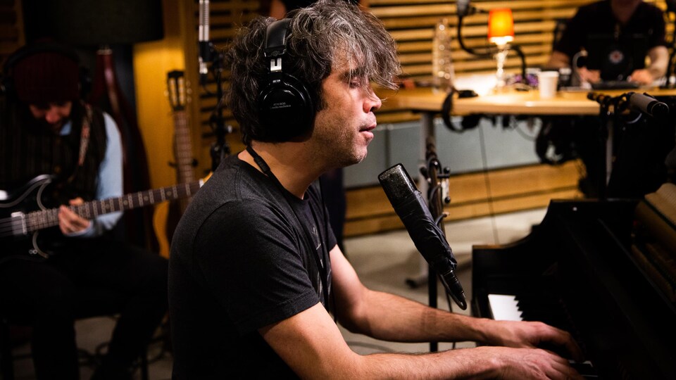 Le chanteur chante en jouant du piano dans le studio 85 de Radio-Canada.