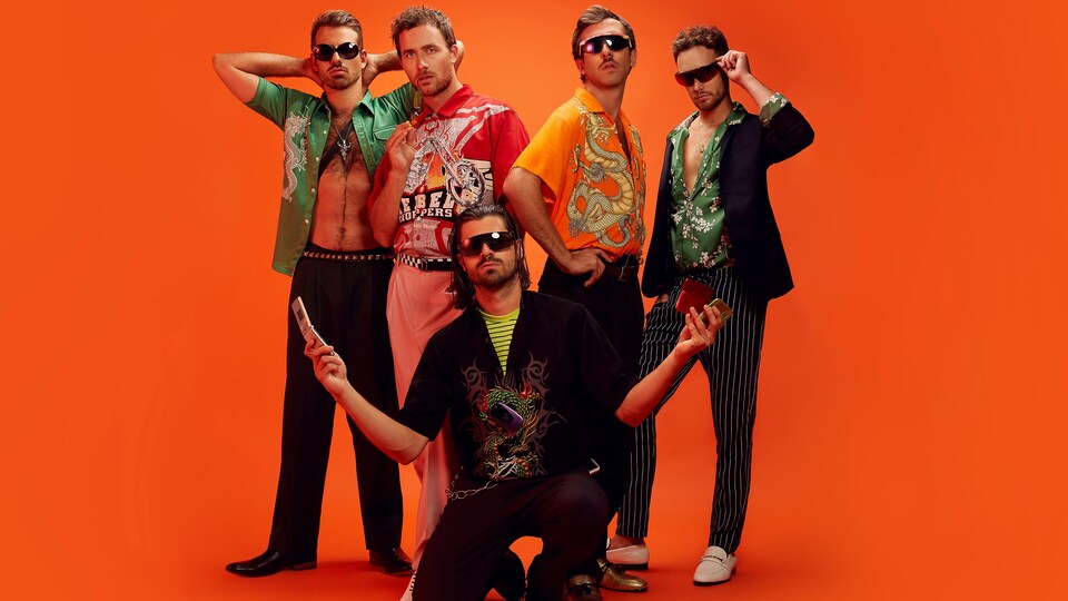 Les musiciens de Qualité Motel posent avec une attitude de mannequin, lunettes fumées incluses.