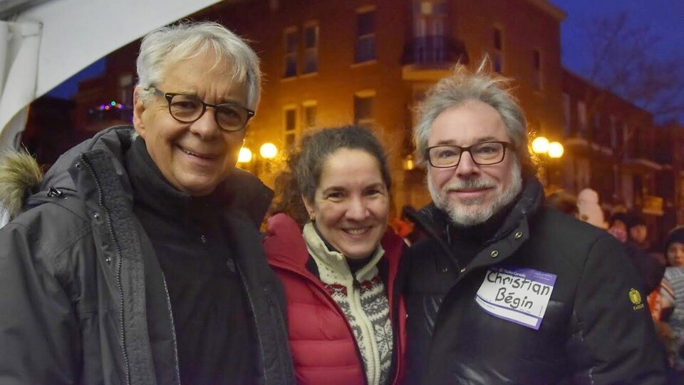 Les trois collaborateurs posent souriants, face caméra, à la lumière de semi-pénombre du petit matin.