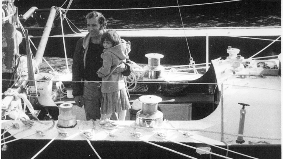 La photo en noir et blanc d'un marin et d'un enfant sur un bateau.